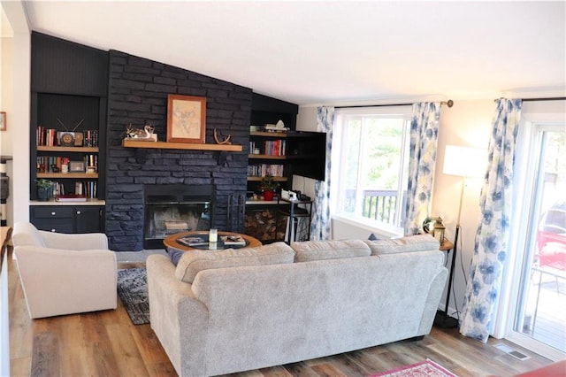 12188 Old Trl, Wisconsin Rapids, WI 54494 - living area featuring plenty of natural light, wood finished floors, vaulted ceiling, and a stone fireplace