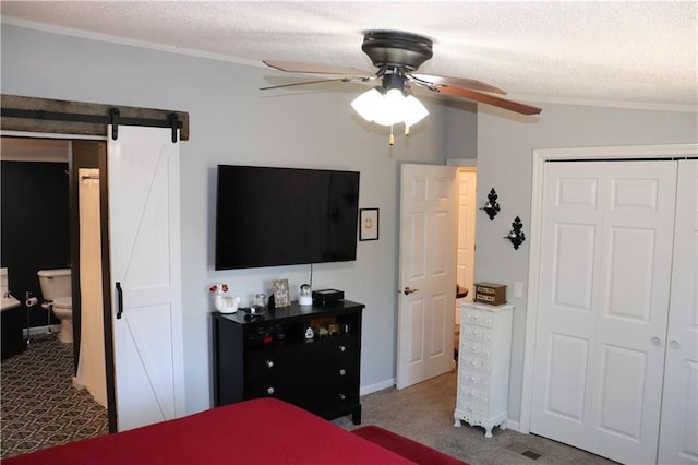 12188 Old Trl, Wisconsin Rapids, WI 54494 - carpeted bedroom with crown molding, a closet, ceiling fan, a barn door, and a textured ceiling