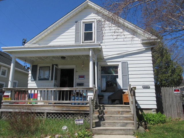 bungalow featuring fence and a porch