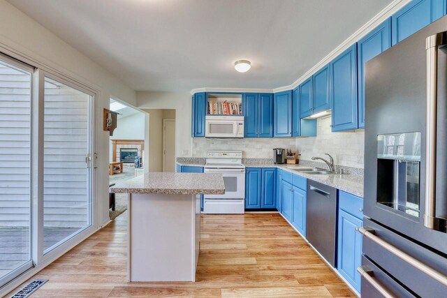 kitchen featuring stainless steel appliances, visible vents, a sink, and blue cabinetry