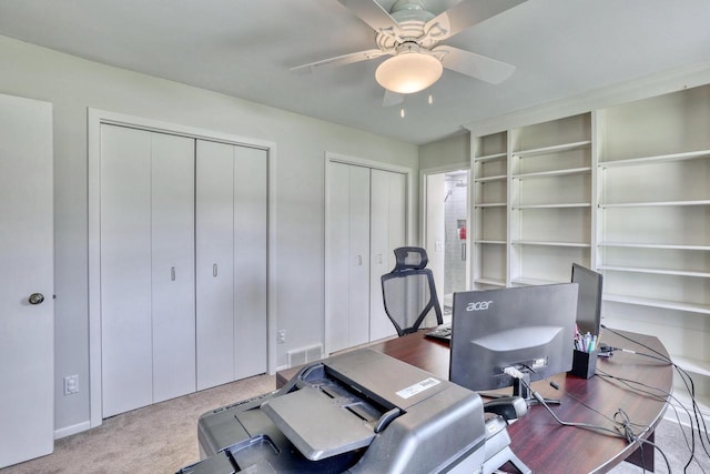 carpeted office with ceiling fan and visible vents