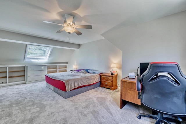 bedroom with carpet floors, ceiling fan, and vaulted ceiling with skylight