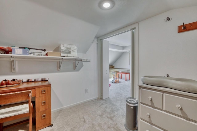 interior space with vaulted ceiling, baseboards, and light colored carpet