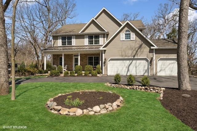view of front of house featuring driveway, a front yard, and covered porch