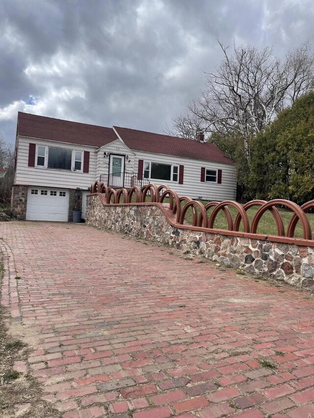 ranch-style house with a garage and decorative driveway