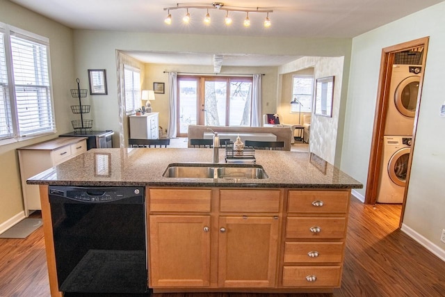 N4142 Sleepy Hollow Rd, Cambridge, WI 53523 - kitchen with a kitchen island with sink, a sink, black dishwasher, stacked washing maching and dryer, and dark wood-type flooring