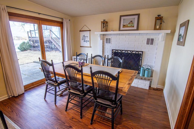 N4142 Sleepy Hollow Rd, Cambridge, WI 53523 - dining area featuring dark wood finished floors, baseboards, visible vents, and a fireplace