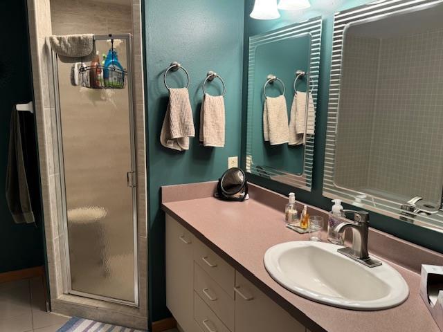 bathroom with vanity, tile patterned floors, and a stall shower