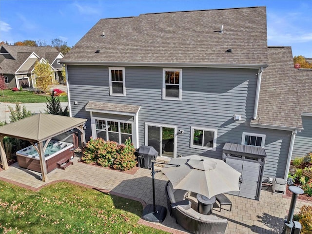 1549 Cambridge Ct, Hubertus, WI 53033 - rear view of house featuring a patio area, roof with shingles, and a hot tub