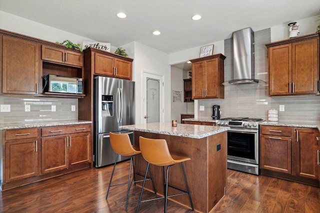 1549 Cambridge Ct, Hubertus, WI 53033 - kitchen featuring wall chimney range hood, appliances with stainless steel finishes, a center island, and dark wood-style flooring