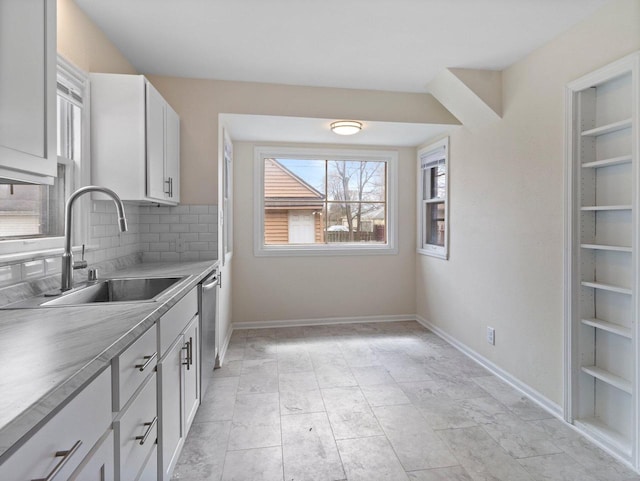 7509 W Burleigh St, Milwaukee, WI 53210 - kitchen with white cabinets, stainless steel dishwasher, a sink, backsplash, and light countertops