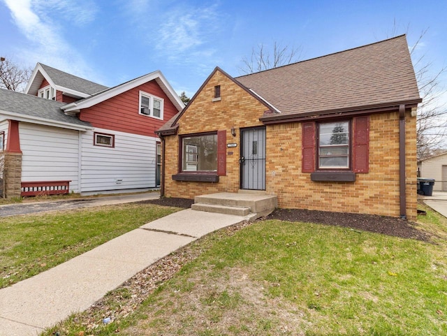 7509 W Burleigh St, Milwaukee, WI 53210 - view of front facade with brick siding, a shingled roof, and a front lawn