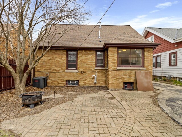 7509 W Burleigh St, Milwaukee, WI 53210 - back of house featuring central AC unit, fence, a patio area, an outdoor fire pit, and roof with shingles