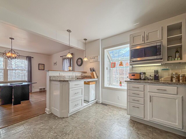 825 Post Rd, Brookfield, WI 53005 - kitchen with stainless steel microwave, baseboards, visible vents, and plenty of natural light