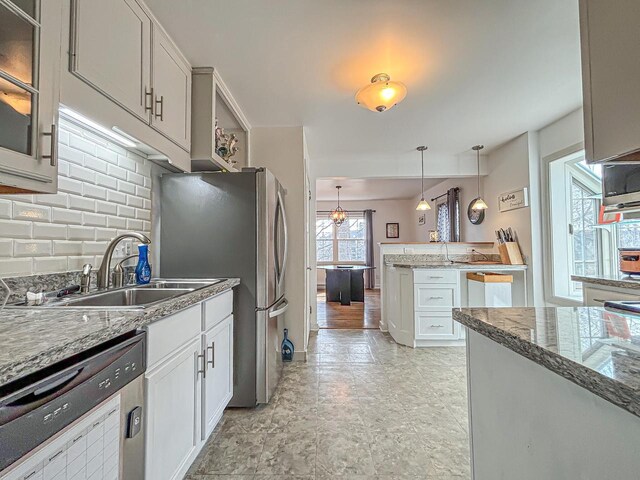 825 Post Rd, Brookfield, WI 53005 - kitchen featuring white cabinets, a sink, tasteful backsplash, dishwasher, and decorative light fixtures