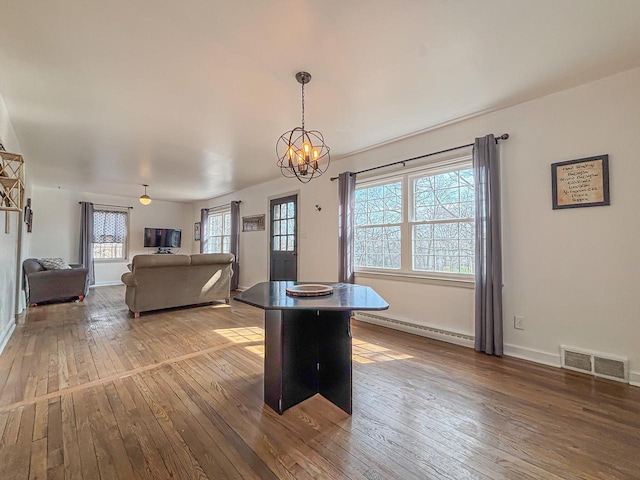 825 Post Rd, Brookfield, WI 53005 - dining area featuring hardwood / wood-style flooring, a baseboard radiator, a chandelier, and visible vents