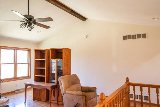 9506 296th Ave, Salem, WI 53168 - interior space featuring baseboards, vaulted ceiling with beams, visible vents, and light wood-style flooring