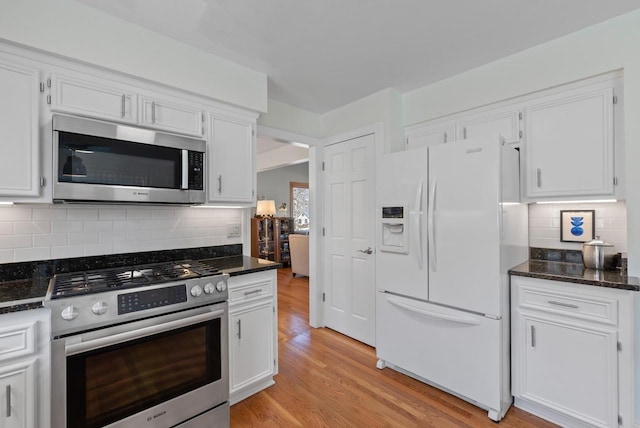 kitchen with white cabinetry, stainless steel appliances, and light wood-type flooring