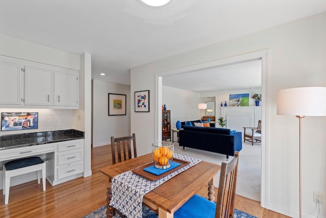 dining room featuring baseboards, built in study area, recessed lighting, and light wood-style floors