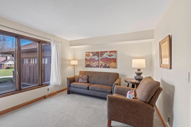 living room featuring baseboards, carpet flooring, and visible vents