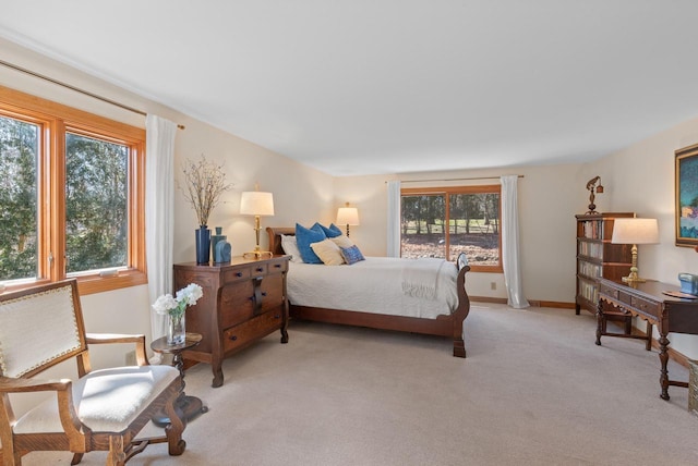 bedroom with light colored carpet and baseboards