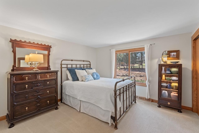 bedroom with visible vents, baseboards, and light carpet