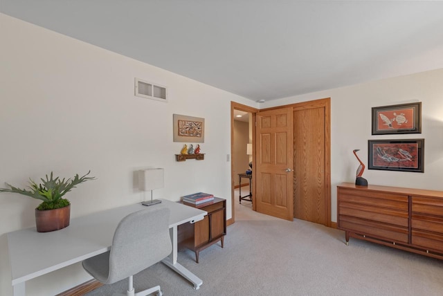 office featuring visible vents, baseboards, and light carpet