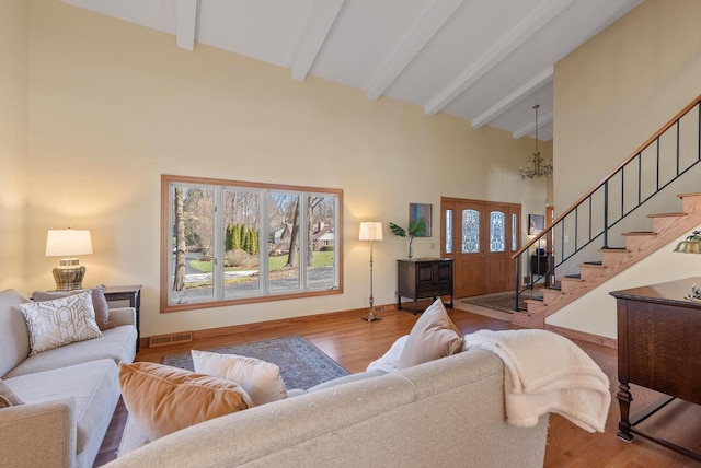 living room with visible vents, stairs, beam ceiling, a chandelier, and high vaulted ceiling