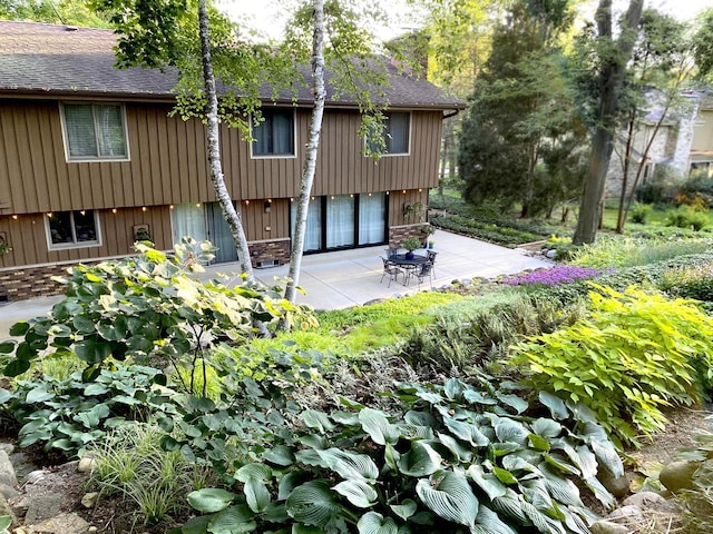 back of property featuring a patio area and roof with shingles