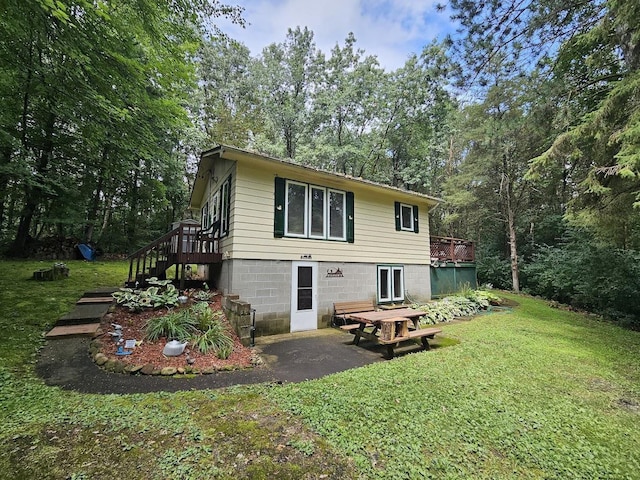 W5691 Cedar Trl, Neshkoro, WI 54960 - back of property with stairs, a yard, a wooden deck, and a patio