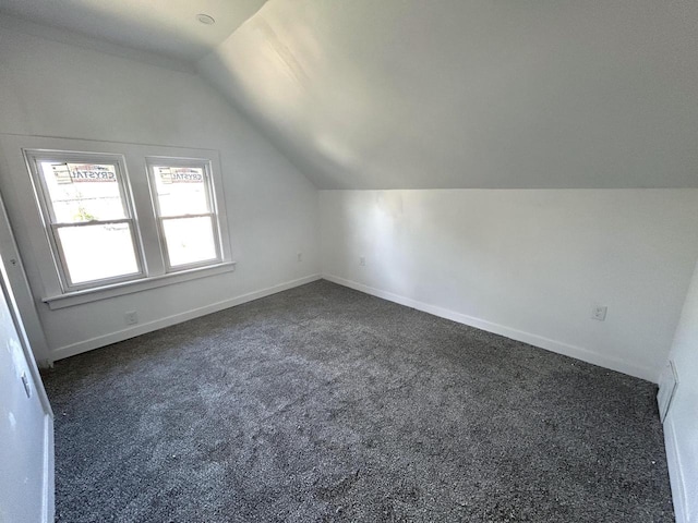 4271 N 26th St, Milwaukee, WI 53209 - additional living space with dark colored carpet, vaulted ceiling, and baseboards