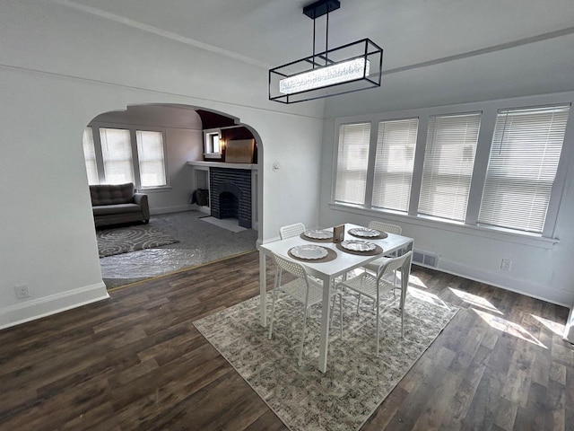 4271 N 26th St, Milwaukee, WI 53209 - dining room with arched walkways, a fireplace, dark wood finished floors, baseboards, and visible vents