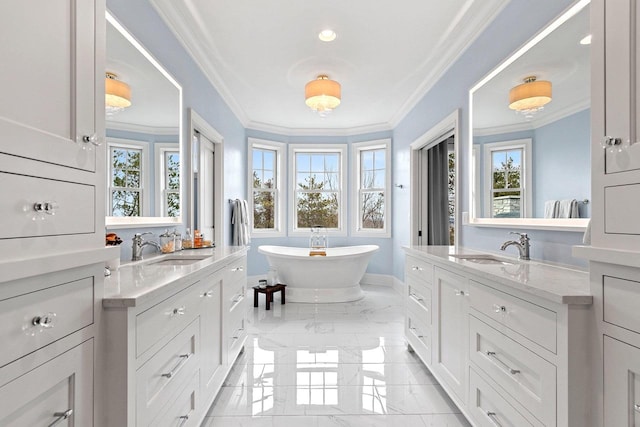 6916 N Palladium Ct, Appleton, WI 54913 - bathroom featuring marble tiled floors, ornamental molding, a freestanding tub, two vanities, and baseboards