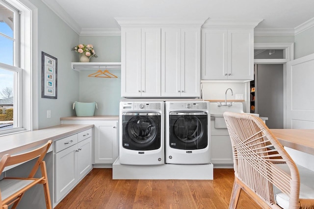 6916 N Palladium Ct, Appleton, WI 54913 - laundry area featuring washing machine and clothes dryer, light wood-type flooring, crown molding, and cabinet space