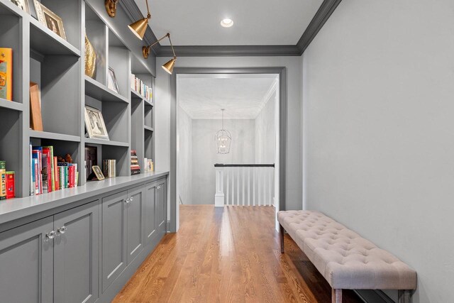 6916 N Palladium Ct, Appleton, WI 54913 - corridor with ornamental molding, light wood-type flooring, a chandelier, built in shelves, and recessed lighting