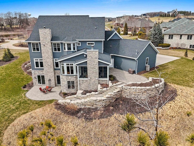 6916 N Palladium Ct, Appleton, WI 54913 - rear view of property with a patio area, stone siding, a chimney, a sunroom, and a lawn