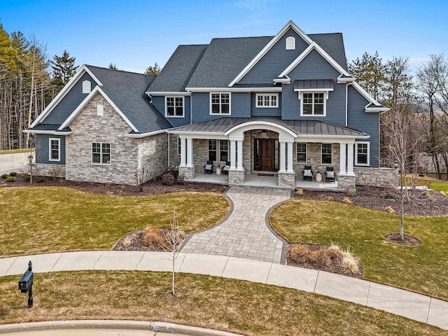 6916 N Palladium Ct, Appleton, WI 54913 - craftsman house featuring a standing seam roof, stone siding, a porch, a front lawn, and metal roof