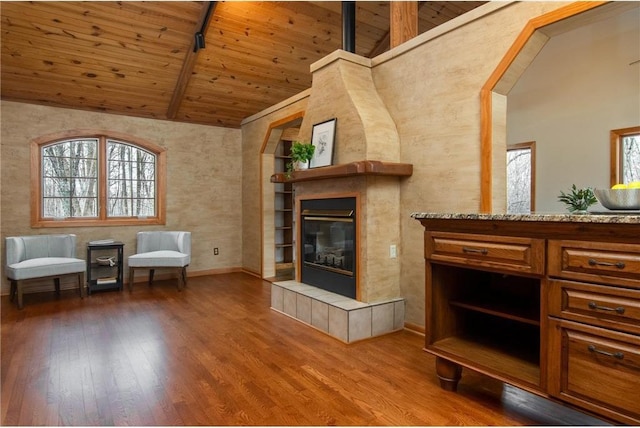 840 Park Dr, Balsam Lake, WI 54810 - living area featuring wood finished floors, wooden ceiling, beam ceiling, baseboards, and a tiled fireplace