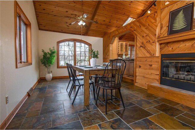 840 Park Dr, Balsam Lake, WI 54810 - dining area with a glass covered fireplace, wood ceiling, ceiling fan, stone tile flooring, and baseboards