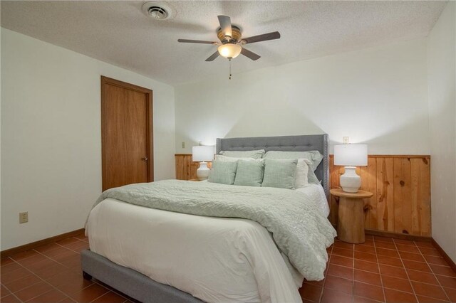 840 Park Dr, Balsam Lake, WI 54810 - tiled bedroom with a wainscoted wall, visible vents, a ceiling fan, a closet, and a textured ceiling