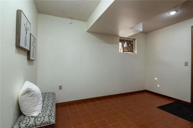 840 Park Dr, Balsam Lake, WI 54810 - basement featuring dark tile patterned flooring, baseboards, and a textured ceiling