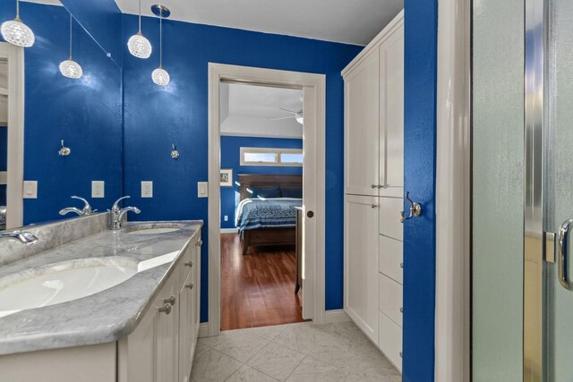 4923 W Woods Creek Ln, Appleton, WI 54913 - full bathroom with double vanity, a sink, connected bathroom, and baseboards