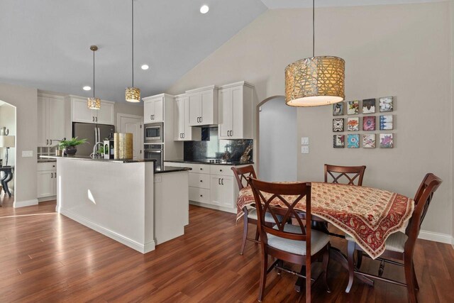 4923 W Woods Creek Ln, Appleton, WI 54913 - kitchen with dark countertops, white cabinetry, dark wood finished floors, appliances with stainless steel finishes, and backsplash
