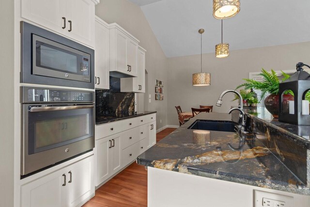 4923 W Woods Creek Ln, Appleton, WI 54913 - kitchen with a sink, stainless steel appliances, white cabinetry, wood finished floors, and lofted ceiling