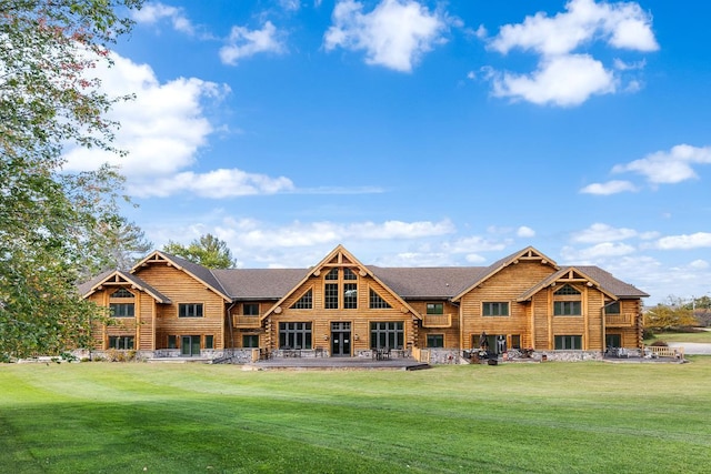 back of property featuring stone siding, a shingled roof, log exterior, and a yard