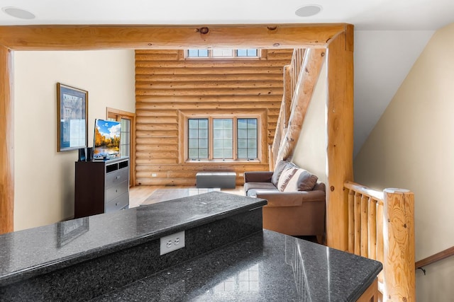 living area with log walls and a healthy amount of sunlight