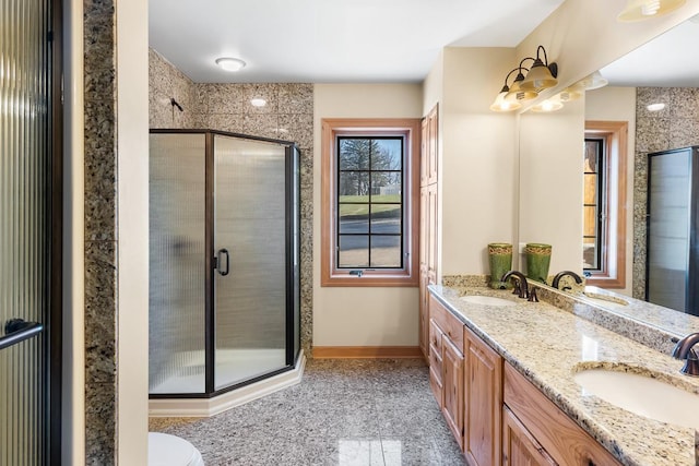 full bathroom featuring baseboards, a sink, and a shower stall