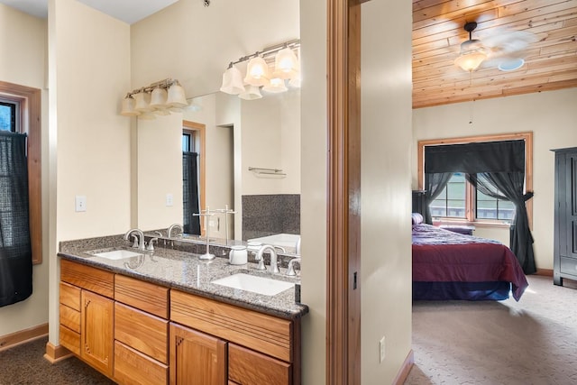 ensuite bathroom with ensuite bathroom, baseboards, and a sink