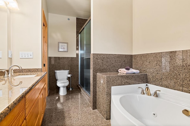 bathroom with granite finish floor, toilet, tile walls, wainscoting, and a stall shower