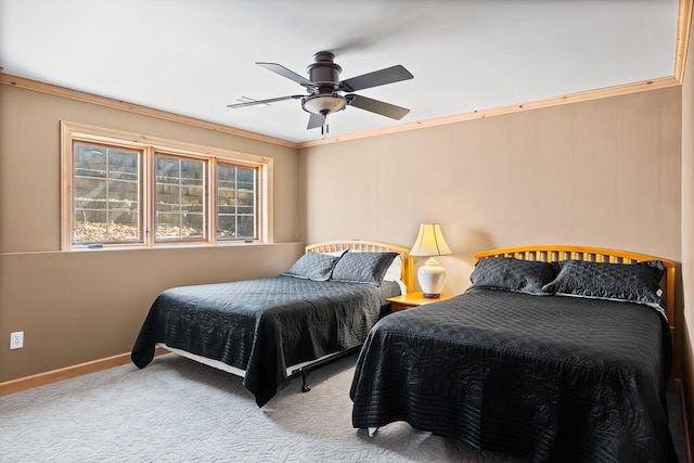carpeted bedroom featuring crown molding, baseboards, and a ceiling fan